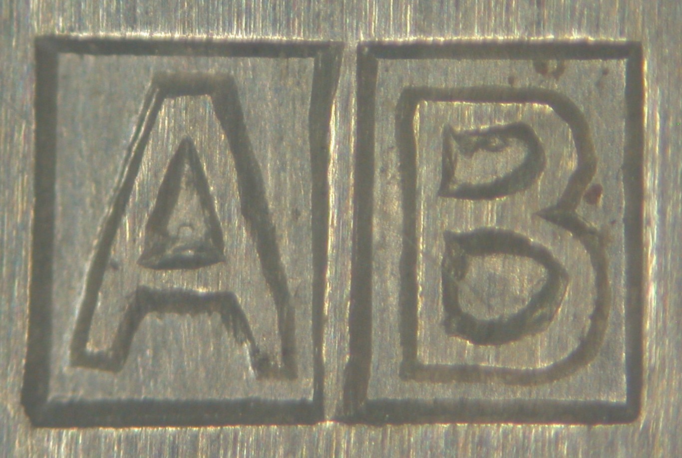 Przykład znaku imiennego: prostokąt podzielony pionowo na pół; po lewej wielka litera A, po prawej wielka litera B